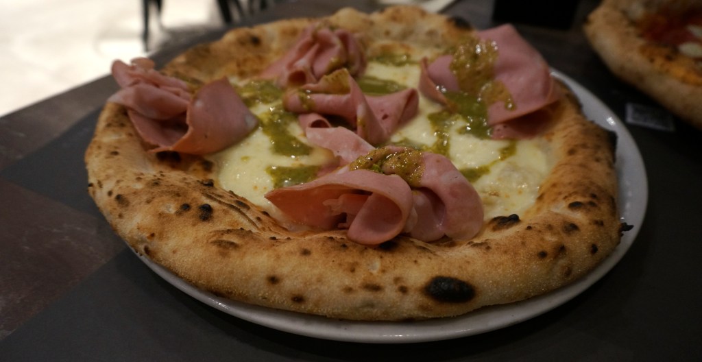 The pistadella pizza from Diego Vitagliano Pizzeria has slices of mortadella, cheese, pistachio pesto, and an incredibly soft pizza crust.