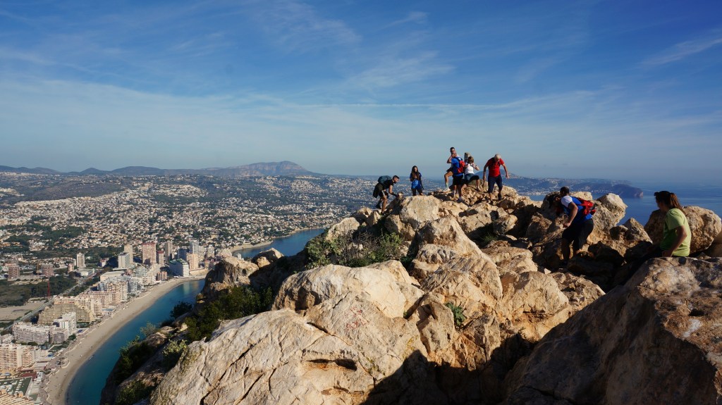 The summit of the Calpe Rock hike in Calpe, Spain. The summit is very rocky and a panoramic view of the coast and the Mediterranean Sea can be seen.